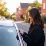 Jeune conductrice à Lille collant son disque A sur sa voiture
